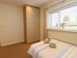 A bedroom with a bed and a wardrobe at Gelli - Morfa Nefyn