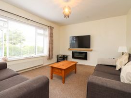 A living room with sofas and a television at Gelli - Morfa Nefyn in Morfa Nefyn