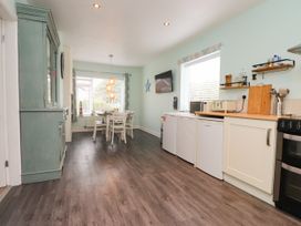 A kitchen with a table and chairs at Gelli - Morfa Nefyn