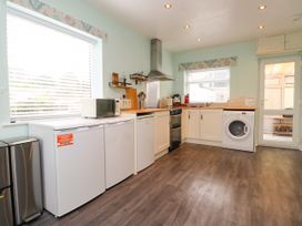 A kitchen with appliances and cabinets at Gelli - Morfa Nefyn