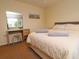 A bedroom with a bed and a desk at Gelli - Morfa Nefyn in Morfa Nefyn