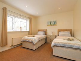 A bedroom with two beds and a nightstand at Gelli - Morfa Nefyn Morfa Nefyn