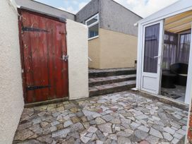 An outdoor area with a wooden door and steps at Gelli - Morfa Nefyn in Morfa Nefyn