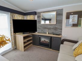A living room with a television and fireplace at Stag Lodge, Caravan 70, Great Yarmouth
