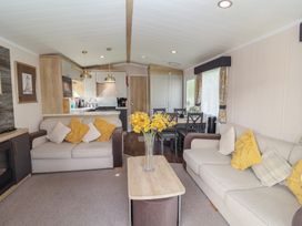 A living room with seating and a dining area at Stag Lodge, Caravan 70 in Great Yarmouth