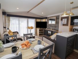 A living room with a dining area and modern furnishings at Stag Lodge, Caravan 70 in Great Yarmouth
