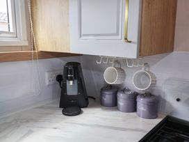 A kitchen counter with a coffee maker and storage canisters at Stag Lodge, Caravan 70 Great Yarmouth