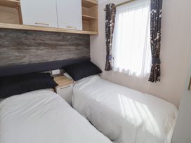 A bedroom with two beds and a window at Stag Lodge, Caravan 70 Great Yarmouth