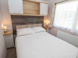 A bedroom with a bed and nightstand at Stag Lodge, Caravan 70 in Great Yarmouth