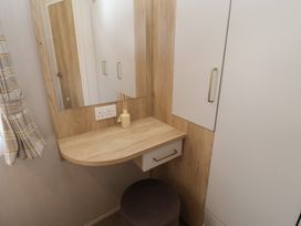 A dressing area with a mirror and shelf at Stag Lodge, Caravan 70 in Great Yarmouth
