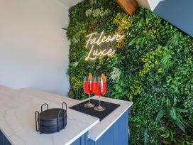 A bar with cocktails and a neon sign at Falcon Luxe in Whitby