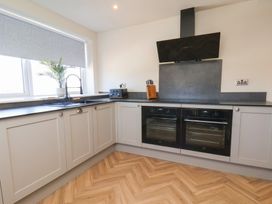 A kitchen with cabinets, sink, and ovens at Falcon Luxe in Whitby