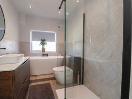 A bathroom with a shower, bathtub, toilet, and sink at Falcon Luxe in Whitby