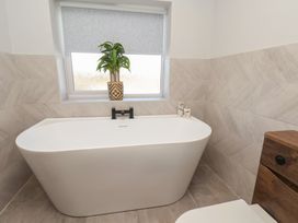 A bathroom with a bathtub and a toilet at Falcon Luxe in Whitby
