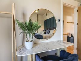 A bedroom with a mirror and plant on a table at Falcon Luxe in Whitby