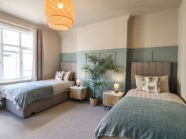 A bedroom with two beds and a plant at Falcon Luxe in Whitby