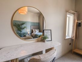 A bedroom with a mirror and a console table at Falcon Luxe in Whitby