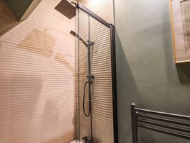 A shower with glass enclosure and showerhead at Falcon Luxe in Whitby