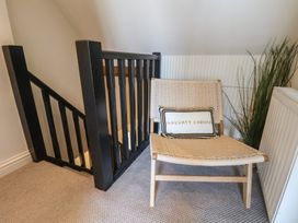 A landing area with a chair and staircase at Falcon Luxe in Whitby