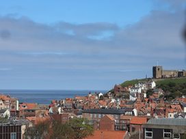 A view of houses and the ocean with a castle at Falcon Luxe in Whitby