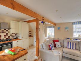 A kitchen with modern appliances and a couch at Half Moon Cottage in Lyme Regis