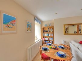A dining room with a table set for a meal at Half Moon Cottage in Lyme Regis
