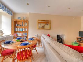 A living room with a dining table set at Half Moon Cottage in Lyme Regis