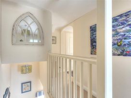 A hallway with a mirror and artwork at Half Moon Cottage in Lyme Regis