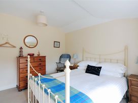 A bedroom with a bed and a dressing table at Half Moon Cottage in Lyme Regis