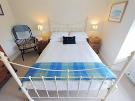 A bedroom with a bed and bedside lamp at Half Moon Cottage in Lyme Regis