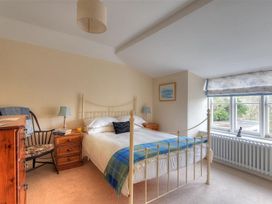 A bedroom with a bed and dresser at Half Moon Cottage in Lyme Regis