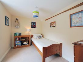 A bedroom with a bed and bookshelf at Half Moon Cottage in Lyme Regis