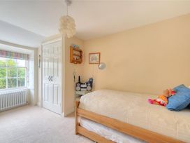 A bedroom with a bed, shelf and stereo at Half Moon Cottage in Lyme Regis