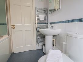 A bathroom with a towel rack and sink at Half Moon Cottage in Lyme Regis
