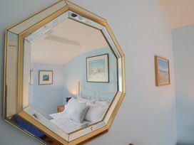 A bedroom with a bed and decorative items at Half Moon Cottage in Lyme Regis