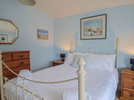 A bedroom with a bed and nightstands at Half Moon Cottage in Lyme Regis