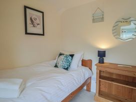 A bedroom with a bed and nightstand at Half Moon Cottage Lyme Regis