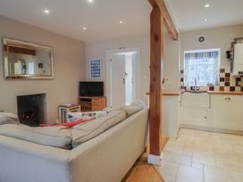 A living room with a sofa and a television at Half Moon Cottage in Lyme Regis