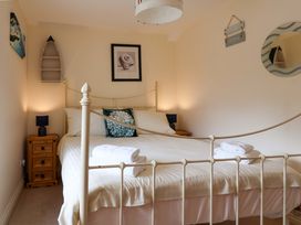 A bedroom with a bed and nightstand at Half Moon Cottage in Lyme Regis