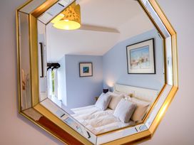 A bedroom with a mirror and painting at Half Moon Cottage Lyme Regis