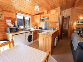 A kitchen with wooden cabinets and dining area at Watendlath in Keswick