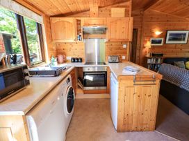 A kitchen with appliances and wooden cabinetry at Watendlath in Keswick