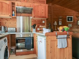 A kitchen with wooden cabinets and appliances at Watendlath in Keswick