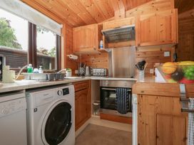 A kitchen with wooden cabinets and appliances at Watendlath in Keswick