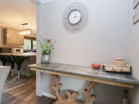 A kitchen area with a table and clock at Costapacket in Windermere