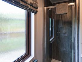 A bathroom with a shower and window at Costapacket, Grasmere 12, White Cross Bay near Windermere