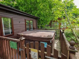 An outdoor area with a hot tub and wooden deck at Costapacket in Grasmere 12, White Cross Bay near Windermere