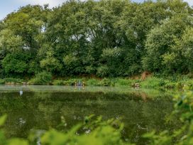 A pond with trees and benches at Pear Tree Carlton Miniott near Thirsk