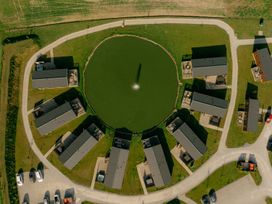 An aerial view of houses surrounding a pond at Pear Tree in Carlton Miniott near Thirsk