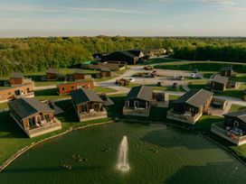 A view of cabins around a pond at Pear Tree in Carlton Miniott near Thirsk